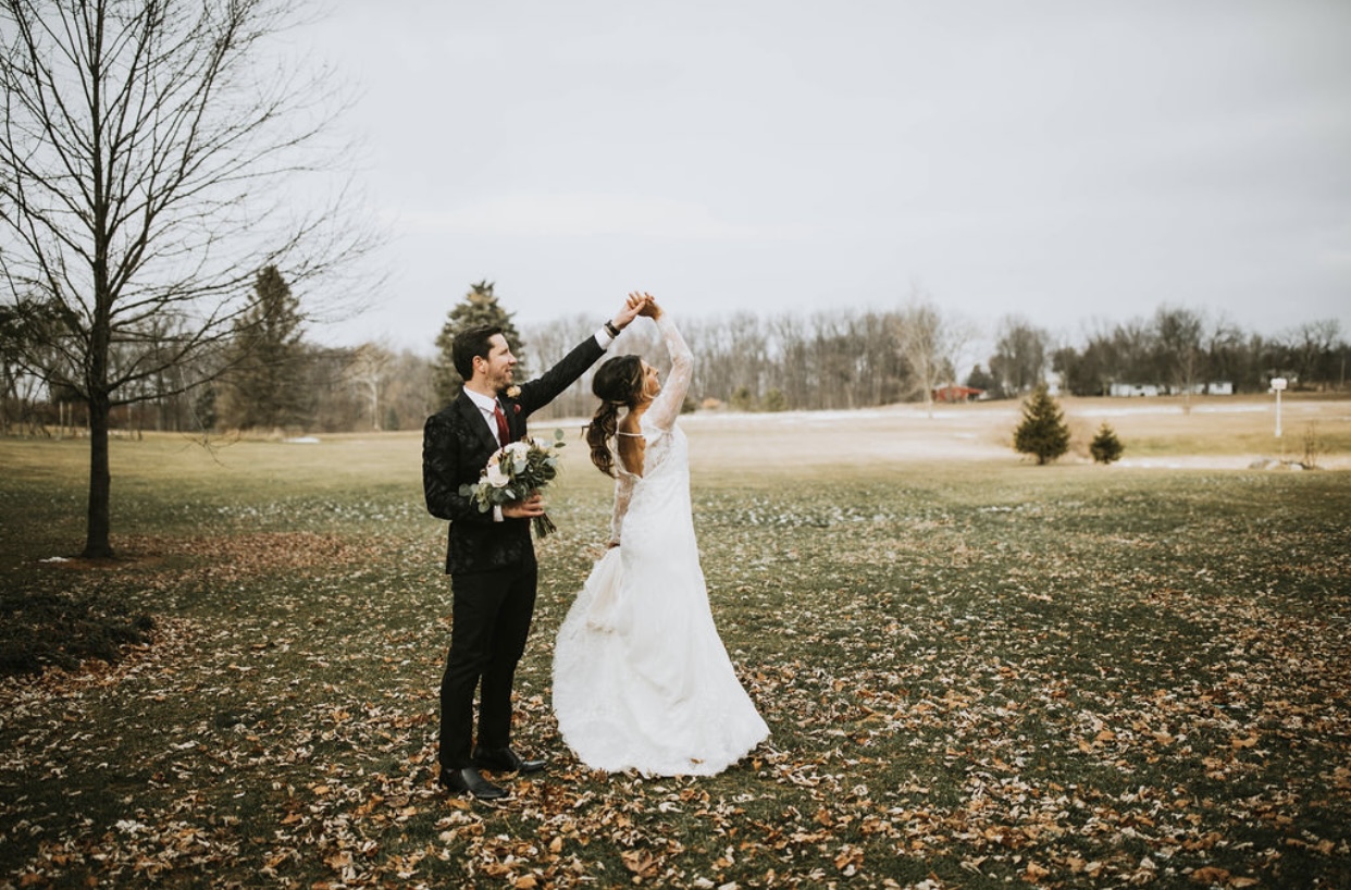 Bride and Groom twirling and hands in field